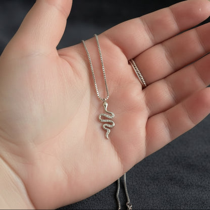 hand holding a snake necklace with 2 rings